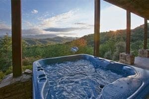 Hot tub on the deck of a cabin with breathtaking mountain views.