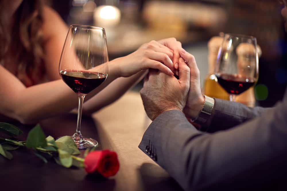 couple-holding-hands-romantic-dinner